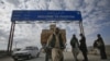 A Pashtun man passes a road sign while pulling supplies toward the Pakistan-Afghanistan border crossing in Chaman.