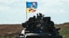 UKRAINE – A Ukrainian tank rides with a flag picturing Ukraine and US flags shaking hands in Novostepanivka, Kharkiv region, on September 19, 2022