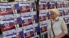 A woman walks past posters showing Russian President Vladimir Putin reading "Welcome, President" in Belgrade on October 15.