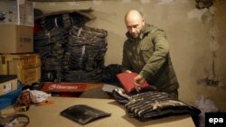 Український волонтер закінчує роботу над бронежилетом з металевою пластиною. Київ. 22 листопада 2014 року