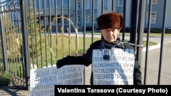 77-летний житель Восточно-Казахстанской области Владимир Тарасов проводит акцию протеста, приковав себя цепью к воротам областного суда. Усть-Каменогорск, 24 октября 2018 года.