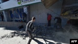 Рабочие снимают заграждения у отделения Сбербанка в Киеве 