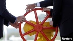 Прем'єр-міністри Словаччини Роберт Фіцо і України Арсеній Яценюк та представник Єврокомісії Клаус-Дітер Борхард запускають реверс газу на українсько-словацькому кордоні, вересень 2014 року