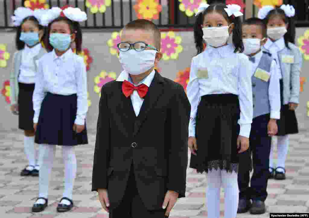 Kyrgyz schoolchildren wearing protective masks maintain a distance of 1.5 meters at their school in Bishkek on September 1.