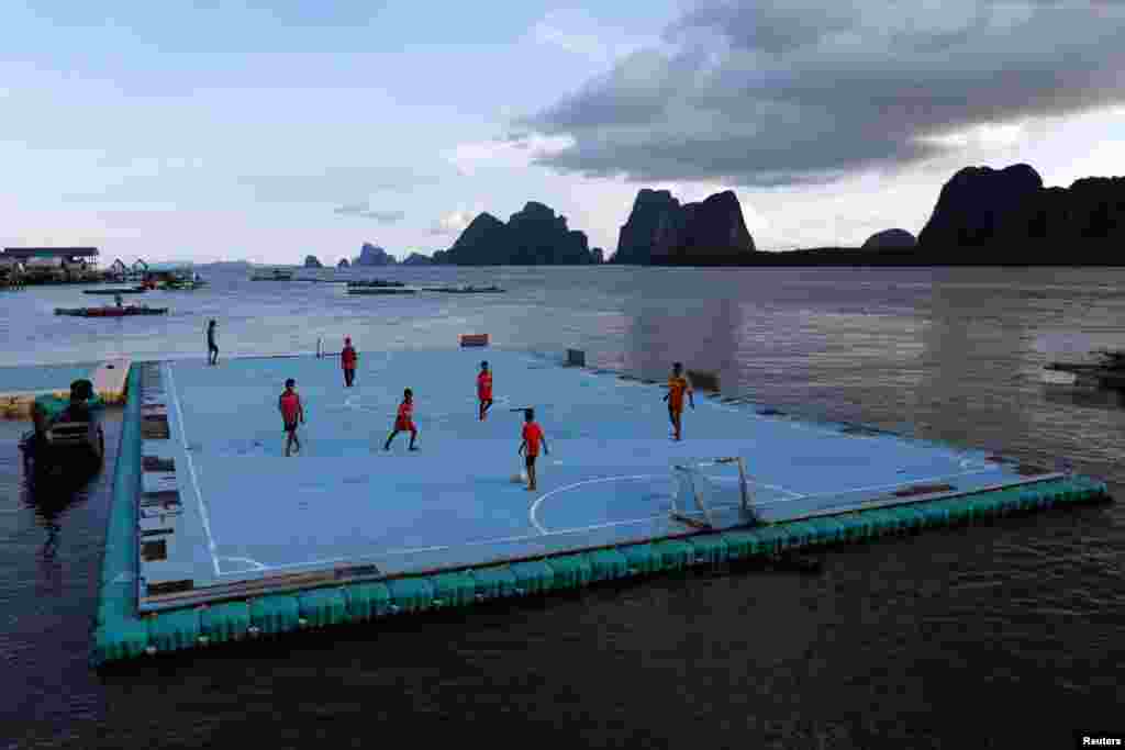 Дети играют на футбольном поле, сооруженном на поверхности воды. Таиланд, 20 мая 2018 года.