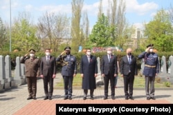 Посол України Євген Перебийніс (другий зліва) з представниками чеської влади на церемонії покладання квітів до пам'ятника загиблим бійцям Червоної Армії, що полягли за звільнення Чехословаччини від нацистів. 8 травняб 2012 року