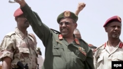 Президент Судана Омар аль-Башир приветствует участников митинга против повстанцев. Хартум, 14 мая 2008 года.  