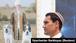 Президенттин уулу Сердар Бердымухамедов атасы Гурбангулы Бердымухамедовдун сүрөтүнүн алдында. 