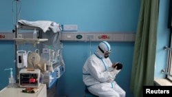 Медработник держит на руках новорожденного с COVID-19. Китай. Иллюстративное фото.