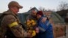 Local resident Valentyna Buhaiova embraces Ukrainian soldiers in the recently retaken village of Kyselivka, outside of Kherson, on November 12.