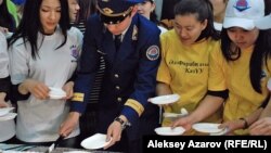 Участники акции в момент разрезания пирога. Алматы, 25 января 2013 года.       