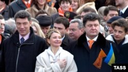 Украина, Киев. Член политсовета российского Союза правых сил Борис Немцов, Юлия Тимошенко и Петр Порошенко (слева направо) во время исполнения гимна на гражданской инаугурации президента Виктора Ющенко на Майдане Незалежности. Фото ИТАР-ТАСС/ Алексей Иванов, 2005