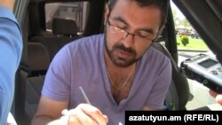 Հայաստան -- Ակտիվիստ Սուրեն Սահակյանը ստորագրում է «Շտապօգնության» աջակցությունից հրաժարվելու մասին իր հայտարարությունը, Երևան, 6-ը օգոստոսի, 2013թ․