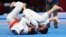 Indonesia Asian Games Ju-Jitsu-Ruslan Israilov of Kazakhstan, right, competes against Nursultan Alymkulov of Kyrgyzstan, left, during Newaza men -77 kg Ju-Jitsu final match at the 18th Asian Games in Jakarta, Indonesia, Sunday, Aug. 26, 2018. (AP Photo/Ac