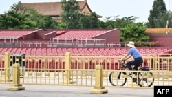 A man rides his bicycle in front of the stands set up in Tiananmen Square for a military parade on September 3 to mark the 80th anniversary of victory over Japan and the end of World War II.