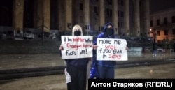 Молодая пара с плакатами троллит силовиков, использующих водомёты