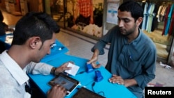 Сим-картаны каттоодон өткөрүү. Карачи, Пакистан. 3-март, 2015-жыл. 