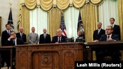 «Це дійсно історичний момент», заявив Дональд Трамп (в центрі), сидячи в Овальному кабінеті разом із Авдуллою Хоті (праворуч) та Александром Вучичем (ліворуч).