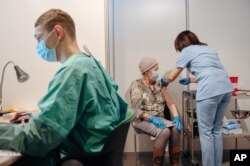 Літня жінка отримує щеплення від COVID-19 в місті Ґданськ на півночі Польщі. 25 січня 2021 року