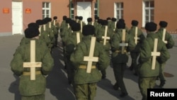 Солдаты тренируют военную выправку, используя деревянные кресты