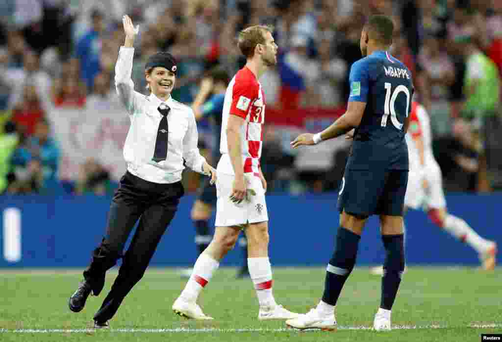 A field invader lunges for a high-five from Kylian Mbappe, France&#39;s star forward.&nbsp;
