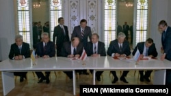 Прэзыдэнт Украіны Леанід Краўчук (зьлева другі), Старшыня Вярхоўнага Савета Беларусі Станіслаў Шушкевіч (зьлева трэці) і прэзыдэнт Расейскай Фэдэрацыі Барыс Ельцын (справа другі) падчас час цырымоніі падпісаньня Пагадненьня аб ліквідацыі СССР і стварэньні СНД. 8 сьнежня 1991 году