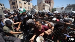  شماری از فلسطینی‌ها در بیرون یکی از کمپ‌های مهاجرین در جریان تلاش برای دریافت کمک