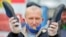 An opposition supporter in Minsk holds a pair of slippers during a rally on May 31 to support a free presidential election in August.