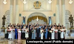 Қазақстан президенті Қасым-Жомарт Тоқаев (ортада) БАҚ саласы қызметкерлерін марапаттау рәсіміне қатысушылармен бірге түскен сурет. Ақорда, 24 маусым, 2025 жыл.