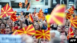 Protesters in Skopje wave flags during one of several demonstrations this year against a law making Albanian the second official language of Macedonia.