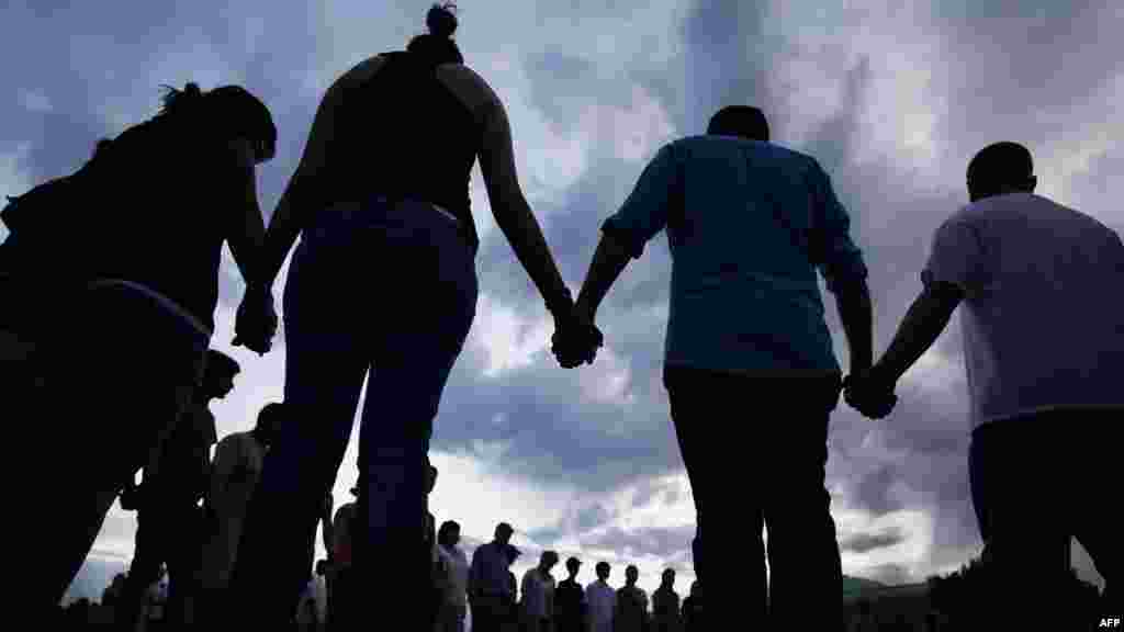 Акция памяти у муниципального центра в Авроре, штат Колорадо, США, 22 июля. За два дня до этого стрелок-одиночка убил в местном кинотеатре 12 человек. (AFP/Джошуа Лотт)