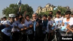 Afghan presidential candidate Abdullah Abdullah talks with a group of cyclists in Kabul on June 6.