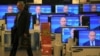 Russia -- A customer walks past the TV screens in a shop during the broadcast of President Vladimir Putin's televised question and answer session with the nation, Moscow, 25Apr2013
