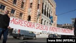 A sign saying "Serbia, An Aggressor, Needs To Be Punished" is seen in front of City Hall in Sarajevo on February 17.