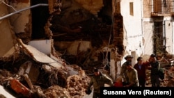 Куткаруучулар суу ташкындан жабыркагандарды жетелеп баратышат. Летур шаары. Испания. 30-октябрь, 2024-жыл.