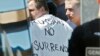 Russian soccer fans suspected of being involved in clashes, with one wearing a banner saying "Russia no surrender," are ushered off their bus after being stopped by gendarmes in Mandelieu near Cannes, France, on June 14.
