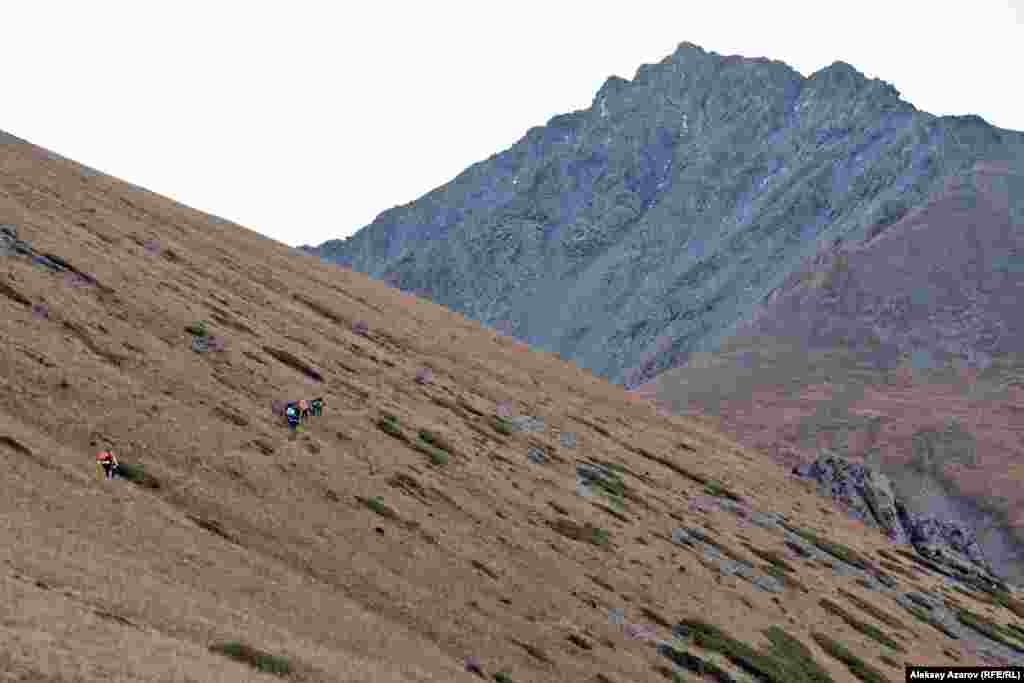 Во время очередного кратковременного рассеяния облаков впереди появилась одна из двух вершин Кыземшека (это название встречается в разных вариантах написания, иногда &ndash; Кыземчек). Ее хорошо видно со стороны озера Иссык, в котором в ясный день она отражается. А это вид на нее с северо-запада. Согласно Алдару Горбунову, топонимом Кыземчек/Кыземшек (в переводе с казахского &laquo;девичья грудь&raquo;) обычно именуют пару островерхих вершин.