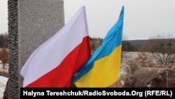 Український та польський прапори на місці поховань поляків у колишній Гуті Пеняцькій, Львівщина, 26 лютого 2017 року