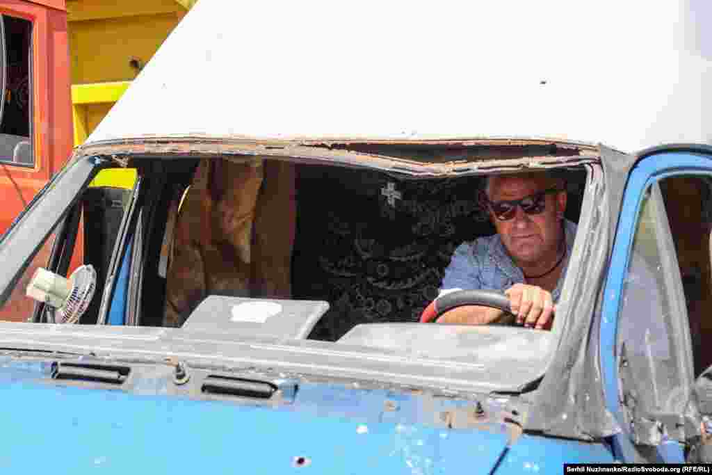 Чоловік у понівеченій ударною хвилею від ракети автівці. Київ, 29 серпня 2025 року.Керівництво Росії заперечує, що російська армія під час масштабної війни завдає цілеспрямованих ударів по цивільній інфраструктурі міст і сіл України, убиваючи цивільне населення і руйнуючи лікарні, школи, дитячі садочки, об’єкти енергетики та водозабезпечення