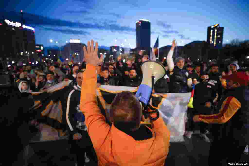 Люди, які протестують проти карантинних заходів через пандемію COVID-19, вигукують &laquo;Свободу!&raquo; біля будівлі уряду в Бухаресті 29 березня. Акції протесту по всій країні пройшли через день після вступу в силу нових заходів ізоляції