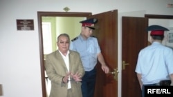 Полицейские выводят в наручниках бывшего советника акима Западно-Казахстанской области Алпамыса Бектурганова в наручниках из зала суда. Уральск, 13 августа 2009 года. 