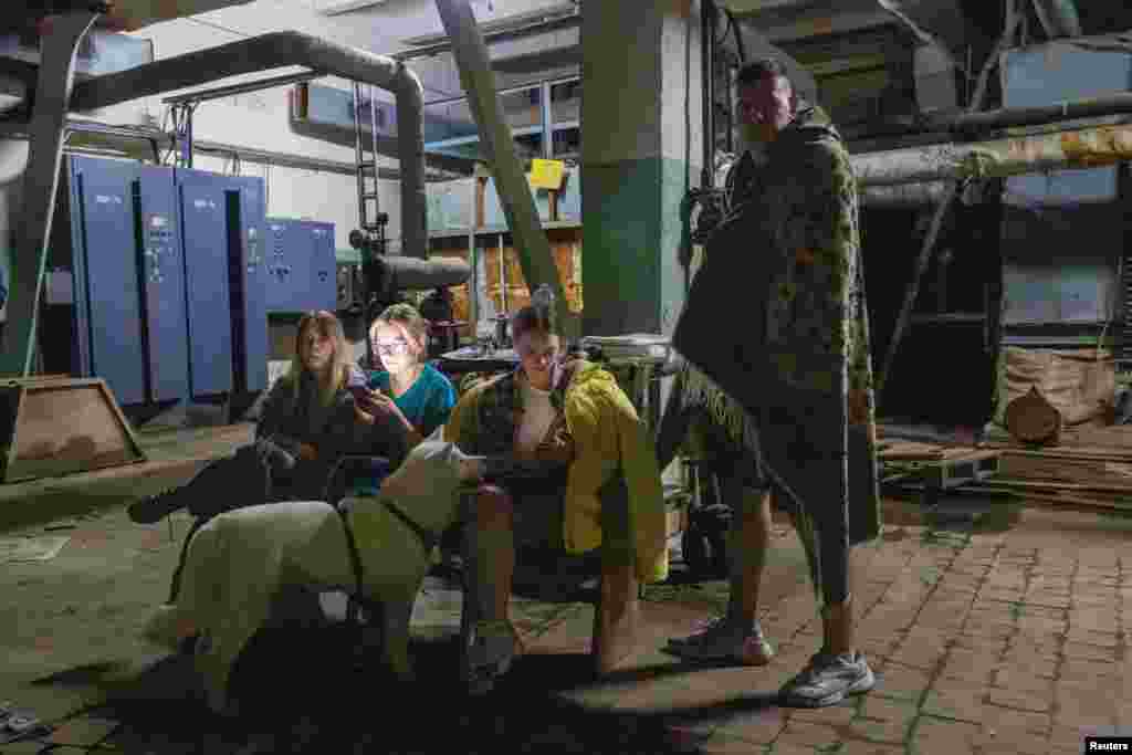 Люди, що живуть по сусідству з атакованою багатоповерхівкою, чекають в укритті на відбій повітряної тривоги.За повідомленнями влади, крім загиблих унаслідок атаки дронів, в укритті під час атаки померла літня жінка