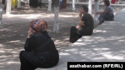 Türkmenistanda köçäniň gyrasynda oturan zenanlar. Illýustrasiýa suraty