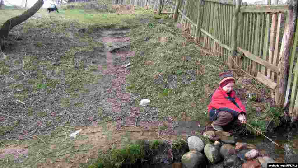 Лёва Капран ловіць «рыбку» ў ручаі, які цячэ проста паўзь іхны ўчастак.