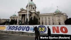 People walk past the Serbian parliament building in central Belgrade.
