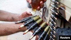 Бойцы ПНС в Триполи, обороняющие город от Халифы Хафтара, смазывают маслом патронную ленту пулемета. Декабрь 2019 года.