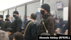 Defendants in the case are seen behind glass in the court in Taraz in December 2020 .
