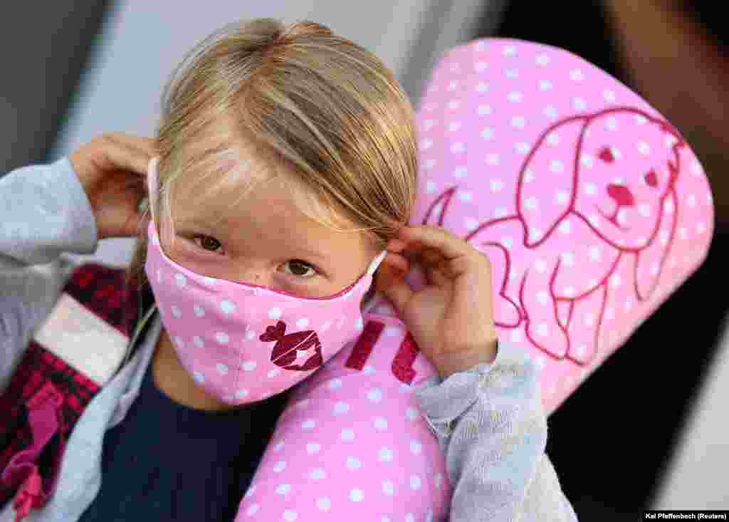 Six-year old Tilda adjusts her face mask before she walks to primary school for the first time after the lockdown in Rodenbach, Germany, on August 18. German schools have been reopening since early August while the number of coronavirus cases among under-20-year-olds remained stable.