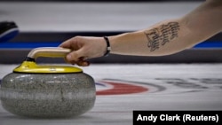 Швециялык атлеттин колуна тартылган, латынча 'Citius, Altius, Fortius!' – "Тезирээк, бийигирээк, күчтүүрөөк!" деген жазуу.  