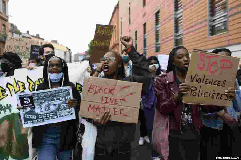 Демонстранти тримають плакати з написами &laquo;Зупинимо жорстокість поліції&raquo; та &laquo;Black Lives Matter&raquo; під час протесту проти насильства поліції, а також в пам&#39;ять про американця Джорджа Флойда та француза Адама Траоре. На протесті були присутні щонайменше 2000 людей. Тулуз, Франція. 10 червня 2020 року